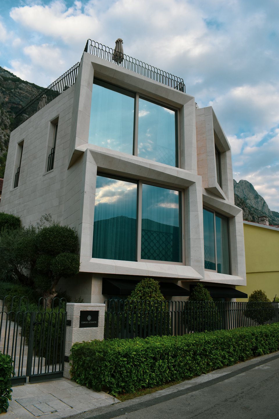 Villa di lusso moderna con facciata in pietra e finestre riflettenti.